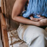 woman grasping stomach in gut health pain