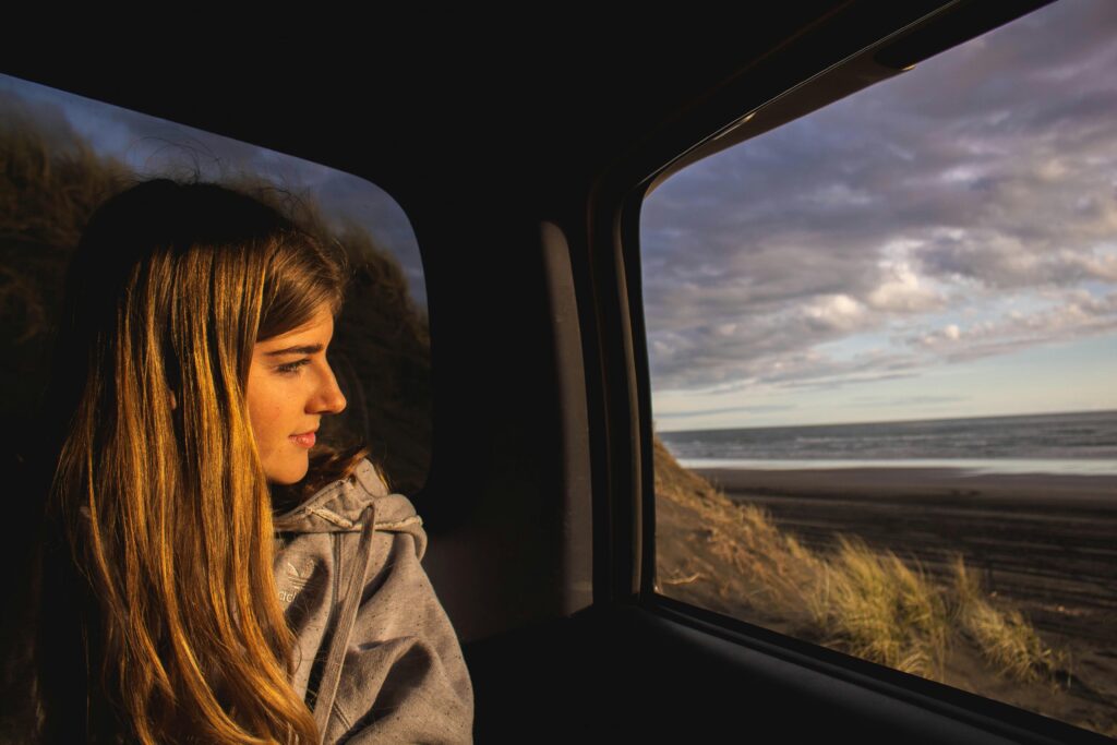 long haired woman looking hopefully out of a car window