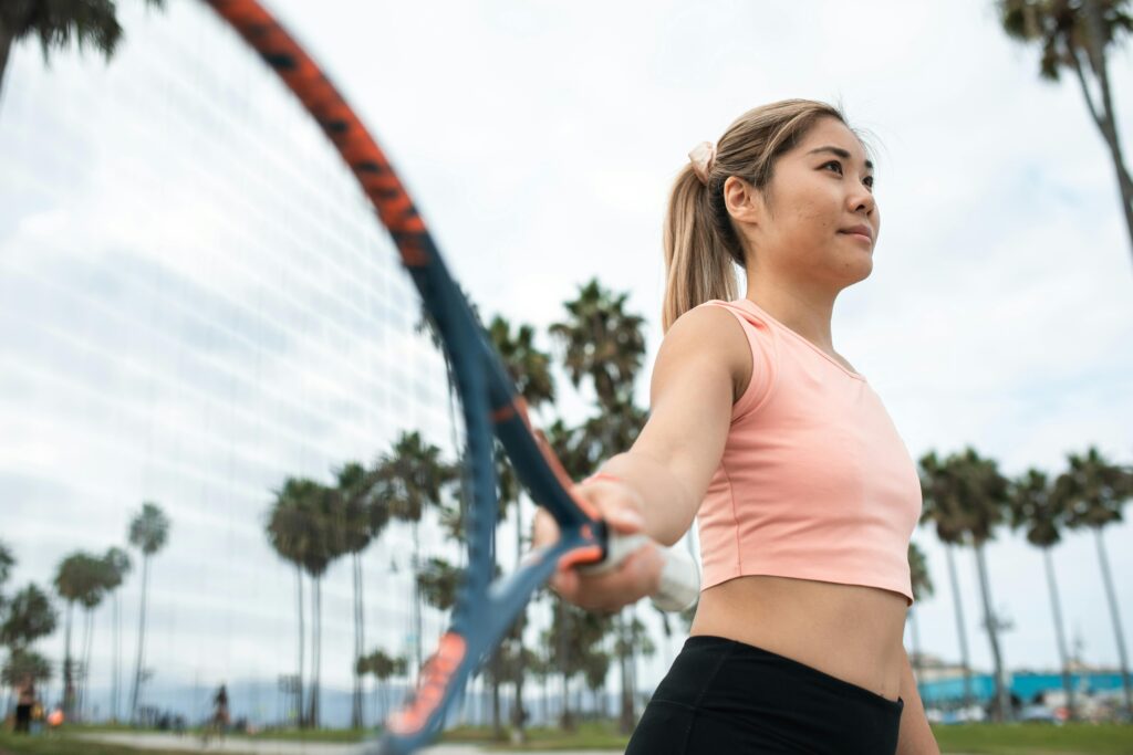 A Woman in Pink Tank Top Holding a Tennis Racket with no elbow pain