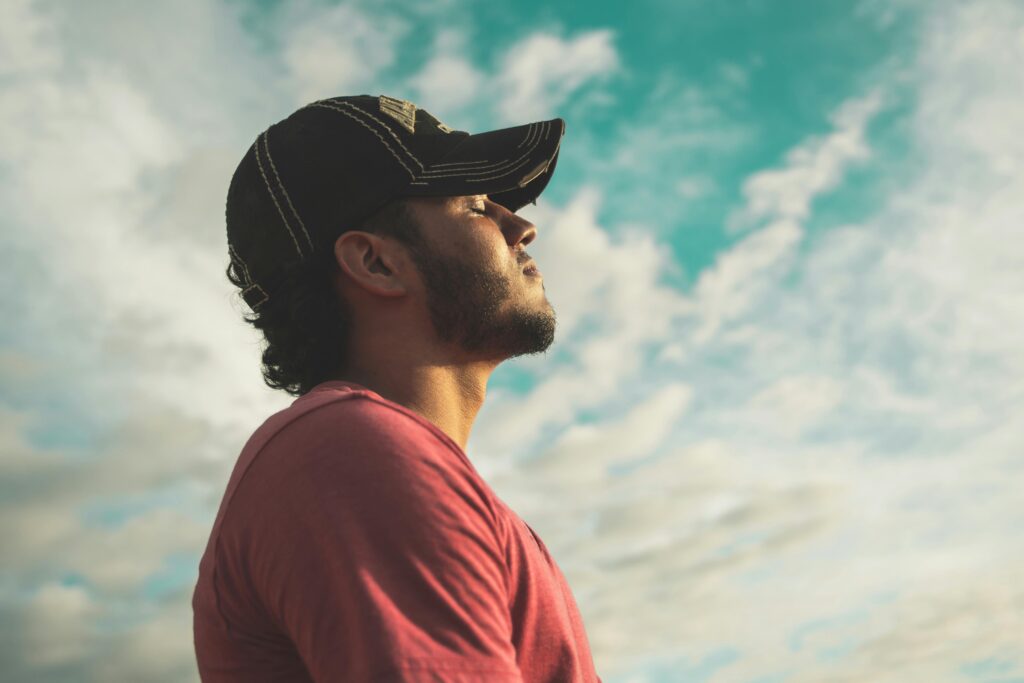 man looking to the sky breathing deeply because he quit smoking