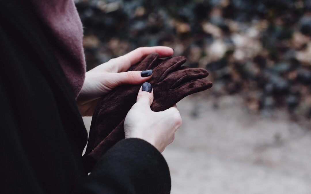 woman with cold hands holding gloves