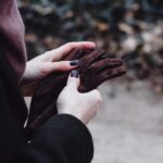woman with cold hands holding gloves