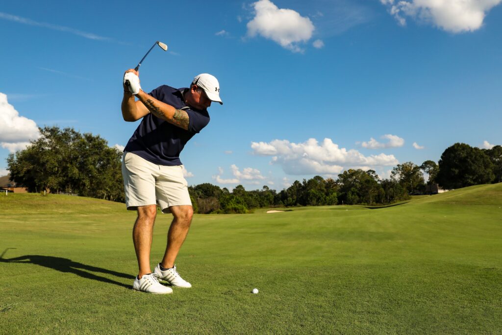 man mid-swing playing golf